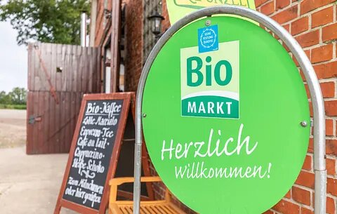 Grünes Willkommensschild vor dem Naturkostladen Häcklingen, Ihr Bio-Markt in Lüneburg